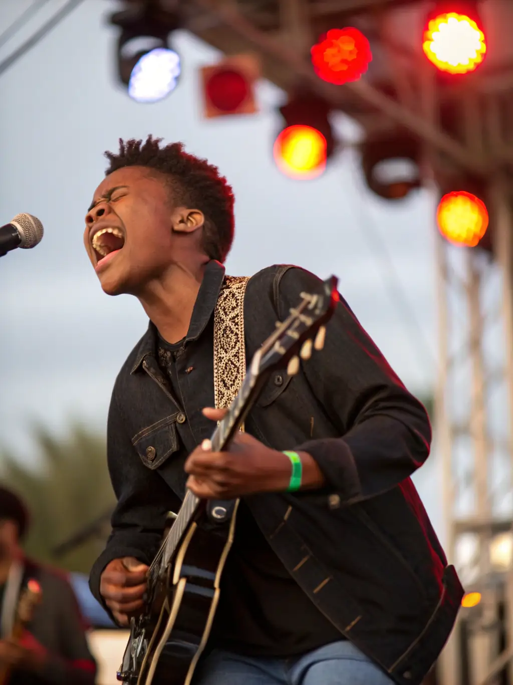 A vibrant image of a young musician playing a guitar during a MUSIC ARTIST workshop, showcasing skill development and artistic expression.